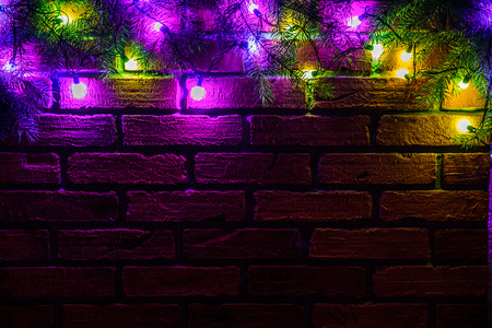 Wreath and garlands of colored light bulbs.Christmas background with lights and free text space. Christmas lights border. Glowing colorful Christmas lights on a brick wall background. New Year.の写真素材
