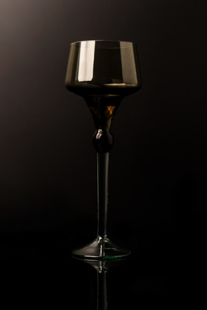 A large glass of dark glass isolated on the black background.の写真素材