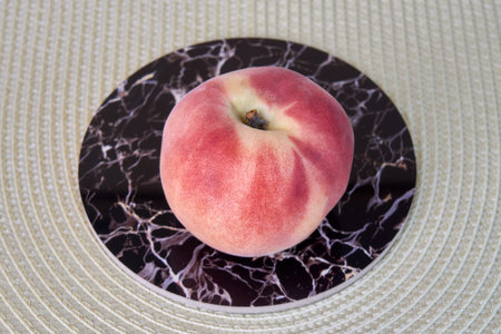 Ripe delicious peach fruit on a light wicker cloth.
