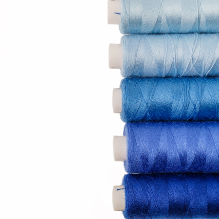 Colored bobbins on white background. Colorful cotton yarns on rolls for sewing.の写真素材