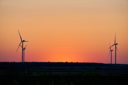Silhouette of wind turbines at sunset. The concept of alternative energy.の写真素材