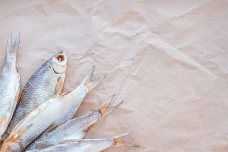 Dried fishes flat lay template banner on craft paper background with empty space for text. Salted roach web cover backdrop. Seafood snack poster, flyer decorative design. Fish frame promotion shop.の写真素材