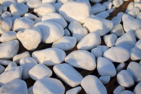 White wet spa pebbles, decorative smooth stones backdrop. Abstract relax natural background. Harmony nature concept for massage, meditation. Summer beach shapesの写真素材