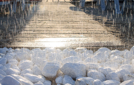 Summer beach shower in bright evening sunlight. Wall tropical rain, drops fall on floor stones....