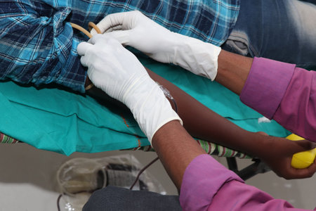 Man gives blood donation with needle in his arm. original image for World blood donor day-June 14.の写真素材