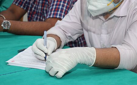 a doctor checking medical patents list due to Coronavirusの写真素材