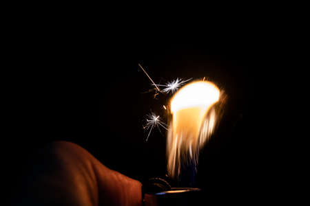 fire sparkle on a lighter in black backgroundの写真素材