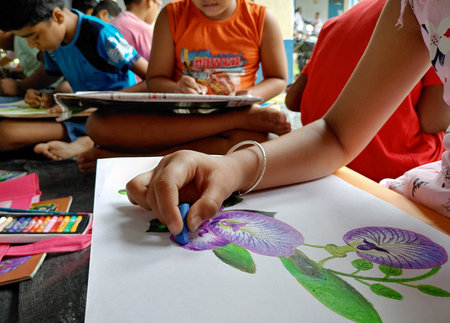 Unidentified Thai students are painting on paper in classroom in Kanchanaburi, Thailand.