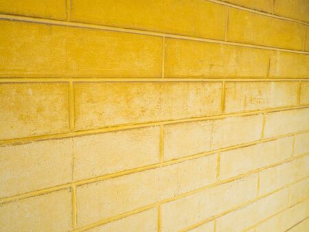 Dark yellow brick wall And pale yellow. Suitable for backgroundの写真素材