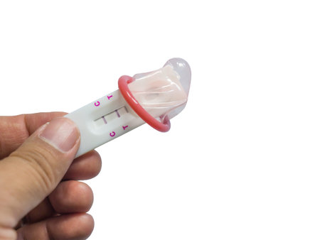 Contraceptives concept. Men holding positive pregnancy tests wearing condoms in his hand on isolated...