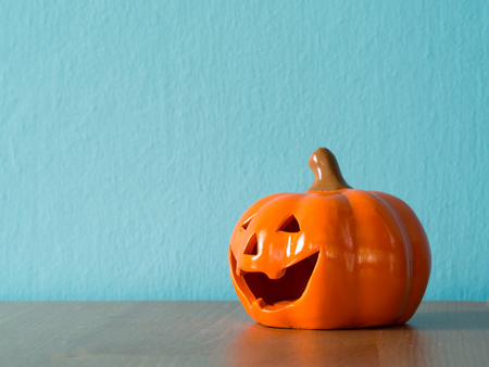 Halloween pumpkin head on the wooden table. the background is blue and copyspace for textの写真素材