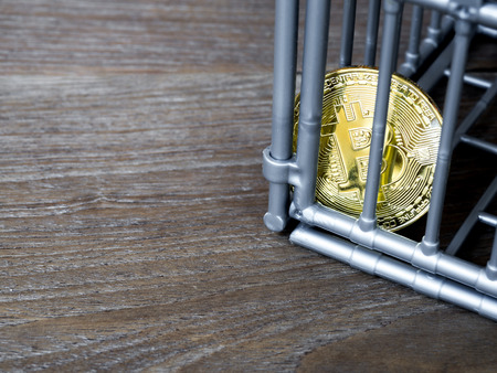 The coin is in the gray nick color put on a wooden table. The concept of investment and fluctuation of bitcoin and cryptocurrency.の写真素材