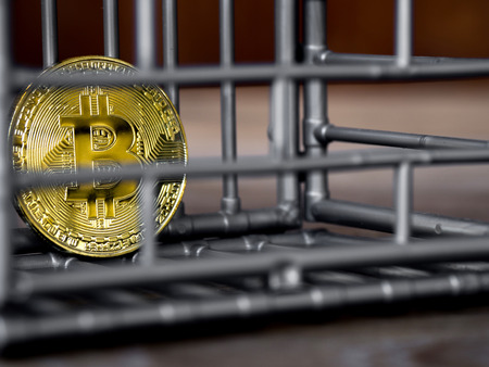 The coin is in the gray nick color put on a wooden table. The concept of investment and fluctuation of bitcoin and cryptocurrency.の写真素材