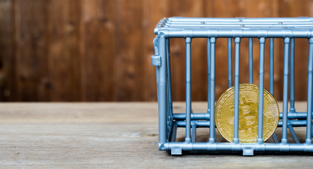 The coin is in the gray nick color put on a wooden table. The concept of investment and fluctuation of bitcoin and cryptocurrency.の写真素材