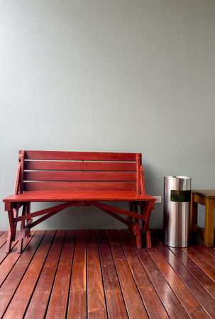 wooden chair beside trash and ashtray in front of the cement wall in smoking area in restaurantの写真素材