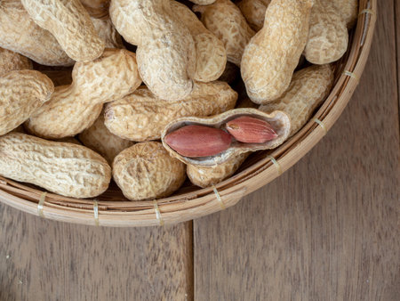 Dried peanuts in shells on peanuts background on wooden table. Concept of snack