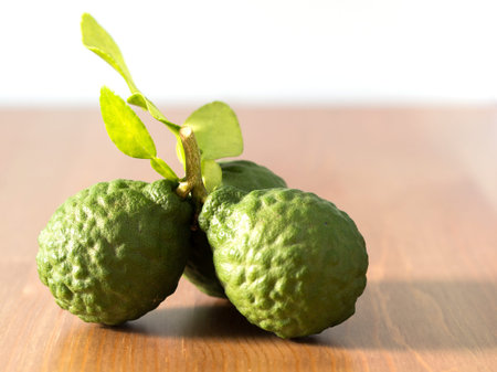 close up group of fresh bergamot with green leaves on wooden table. benefits of bergamot for beauty...