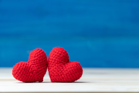 Valentines day concept. hand make two yarn red heart on wooden table and blue backgroundの写真素材