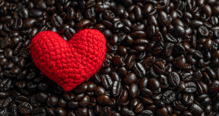 red heart on a lot of roasted coffee beans background. Strong black espresso, Grains of coffee background, textureの写真素材