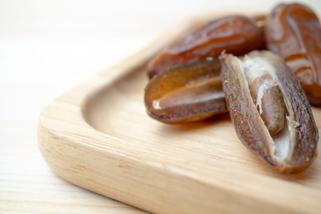 Dried of sweet dates palm fruits on wooden plate. Dates is a dried fruit that provides high energy.