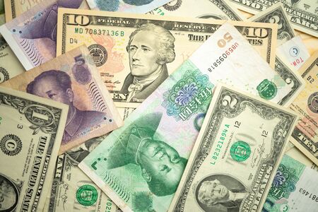 US dollar stack and Chinese yuan banknotes on the table The concept of a trade war between the United States and Chinaの写真素材