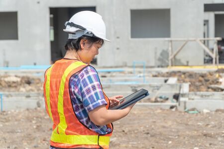 Asian women engineering holds a tablet for use in the inspection of construction sites for accuracy and in accordance with the plan. Concept of Equal rights between men and womenの写真素材