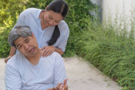 The patient is Cerebrovascular accident or stroke Caused by hypertension and obesity, sitting in wheelchair him mouse is facial palsy, him wife takes care. Concept of healthcare and medical serviceの写真素材