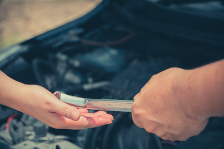The head of technician the car engine repairman service is sending a wrench to the co-worker....