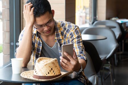 young business farmers sitting in a restaurant and watching smartphones to learning information in agriculture. Concept of modern agriculture.の写真素材