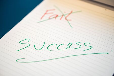 Fild text with a hand with a red pen And crossed out with a green pen on the notebook. Success message by hand with a green pen below the fail. The concept of âânot giving up on failure.の写真素材