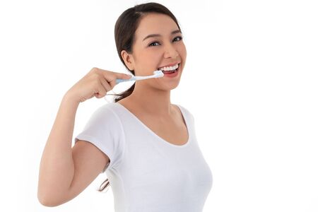 Beautiful Asian woman holding a toothbrush for brush teeth. Her is smile and teeth are white and beautiful and look hygiene. Concept for oral and dental care on the dentist adviceの写真素材