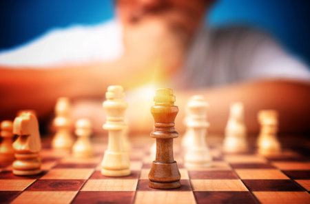 Selective focus of brown king chess and background of businessman thinking strategy and competitor...