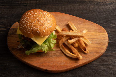 fresh tasty homemade hamburger with fresh vegetables, lettuce, tomato, cheese on a cutting board...