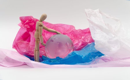 Wooden puppet touch the crystal globe on plastic bag and feel worried and have to protect the earth....