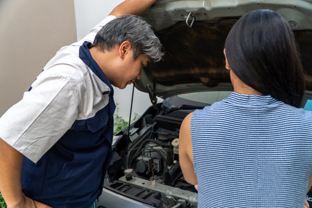 woman who owns the car standing and looking for auto mechanic Check the engine to find the cause.
