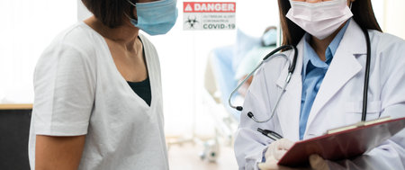 Asian doctor standing in front Quarantine room of and explaining patient relatives About symptoms