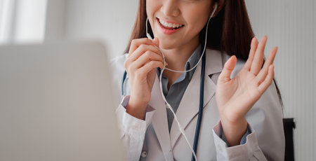 Asian woman doctor is online visiting with a patient on the internet application and Listening of...