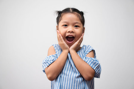 Portrait of Asian child 5 year old and to collect hair and a big smile on isolated white background, She is Happiness, radiance in youthの写真素材