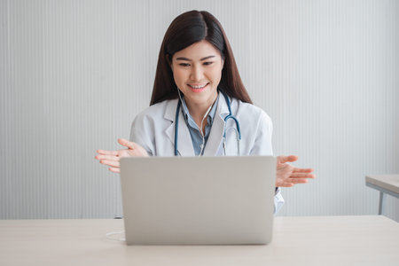 Asian therapist woman doctor is online visiting with a patient on the internet application. Her...