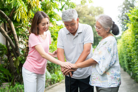 Happy family walking together in the garden. Old elderly using a walking stick to help walk balance. Concept of  Love and care of the family And health insurance for familyの写真素材