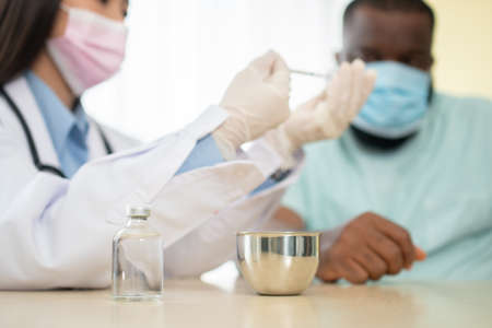Doctor filling up a syringe for vaccinationの写真素材