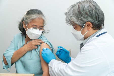Doctors wear medical masks and vaccinated to senior women patients for the prevention of virus and...