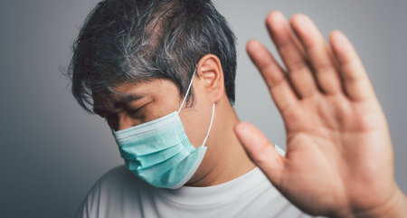 Sick Asian man wearing a medical face mask and Shoulder pain and stress. Concept of protection...