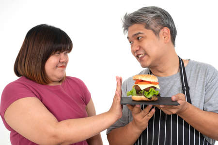 The fat Asian healthy woman Refuse to eat the burger. Concept of healthcare and nutritious foodの写真素材