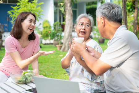 Unhappy Asian senior woman anorexia and say no to meals, Elderly live with family and caregivers try feed food and old woman no appetite, Concept of healthcare and elderly caregiversの写真素材