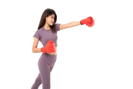 Portrait of beautiful Asian woman standing smile wearing the red boxing gloves,  studio shot isolated on white background, Concept of fitness, exercise and healthyの写真素材