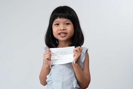 Portrait of Asian girl kid with protective face mask ready for new school year with pandemic restrictions. Concept of kid going back to school and new normal lifestyleの写真素材