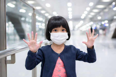 Little girl with surgical mask face protection flu and Virus outbreak in public transportation (skytrain or subway). Concept of New normal lifestyle, Using public transport to travel to school.の写真素材
