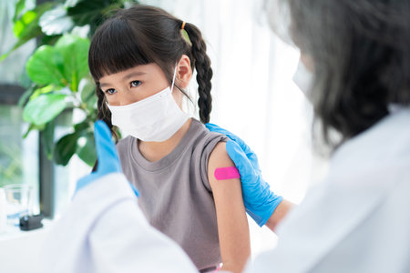 Doctor is affixing the medicinal plaster after vaccinated in shoulder of Asian girl kids in...
