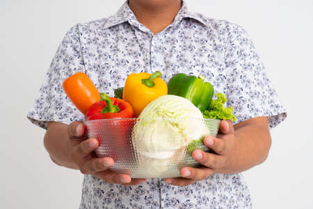Portrait of asian man holding bowl full of fresh organic vegetables isolated on white background, concept of healthy food nutrition, Concept of healthy food nutrition, vegetarianの写真素材